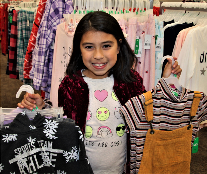 Operation School Bell girl holding clothes she purchased